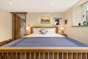 圣大卫Awel y Môr - 3 Bedroom Cottage - Whitesands的一间卧室配有一张带蓝色棉被的大床