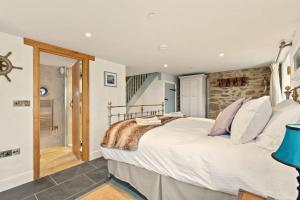 圣大卫Swn y Môr - 1 Bedroom Cottage - Whitesands的一间卧室设有一张大床和石墙