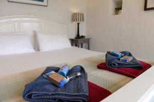 圣大卫Tan y Garn - 2 Bedroom Cottage - Whitesands的酒店客房,配有一张带两条毛巾和一瓶Ooxidehiba的床铺。