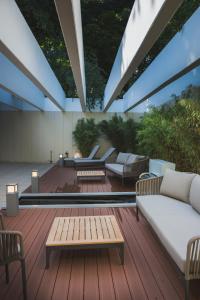 汉诺威艾林瑞德斯提福特公寓酒店的木制甲板上配有沙发和桌子的庭院