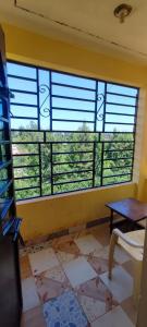2 bedrooms furnished houses in Mwea的客房设有带百叶窗的大窗户。