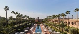 马拉喀什塞尔曼马拉喀什酒店的一座带游泳池、棕榈树和大楼的度假村