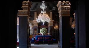马拉喀什塞尔曼马拉喀什酒店的大型客房配有蓝色的沙发和吊灯。