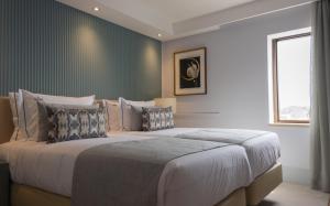 里斯本VIP Executive Suites do Marquês Hotel的一间卧室设有一张大床和一个窗户。
