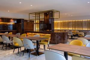 里斯本VIP Executive Suites do Marquês Hotel的餐厅设有木桌和黄色椅子