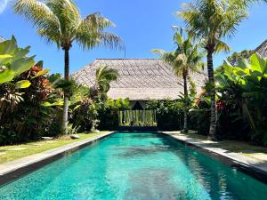 沙努尔Karmagali Suites Adults only & Private Pool Family Villas的棕榈树屋前的游泳池
