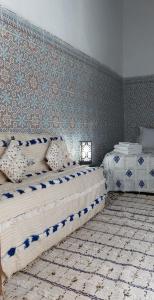拉巴特Riad Diafa的一间卧室设有两张床和一堵墙