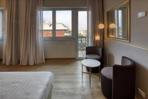 米兰Hotel Nasco的酒店客房设有一张床、两把椅子和一扇窗户。