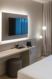 米兰Hotel Nasco的一间设有一张桌子的房间,墙上有一台电视机