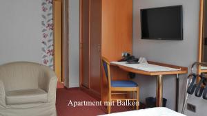 迪布利希Hotel-garni-Kachelburg的客房设有书桌、电视和椅子。