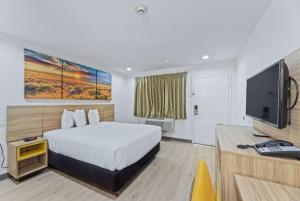 麦金尼麦金尼戴斯酒店的配有一张床和一台平面电视的酒店客房