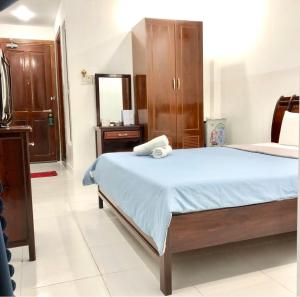 胡志明市Saigon Cozy2 Hotel的一间卧室配有一张带蓝色床单和镜子的床