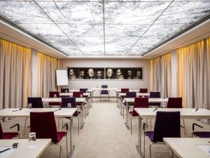 慕尼黑慕尼黑铂尔曼酒店的用餐室配有桌椅和一幅画作