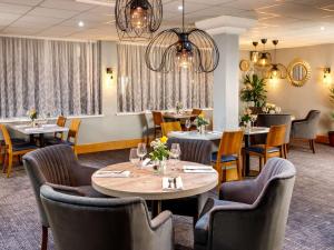 哈洛哈洛丽柏酒店的用餐室配有桌椅和吊灯。