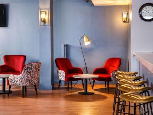哈洛哈洛丽柏酒店的一间设有红色椅子和桌子的等候室