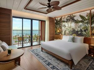 潘切Mövenpick Resort Phan Thiet的一间带大床的卧室和一间客厅