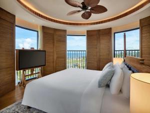 潘切Mövenpick Resort Phan Thiet的卧室配有白色的床和平面电视。