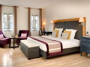 曼特农Hotel Castel Maintenon的一间卧室配有一张大床和两把椅子
