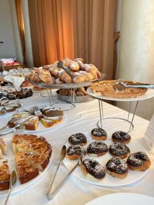 托雷圣乔万尼乌乔尼科酒店的一张桌子,上面放着几盘糕点和馅饼