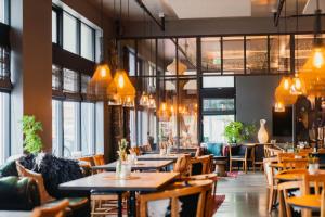 雷克雅未克艾加古斯米登酒店的餐厅设有桌椅和窗户。