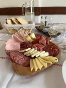 布朗Guest House Piatra Craiului的桌上的一块不同种类的肉和奶酪