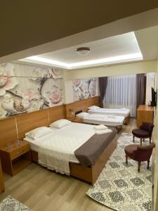 伊斯坦布尔İHVA HOTEL PİERRELOTİ的一间卧室设有两张床,墙上挂着一幅画