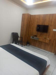 艾哈迈达巴德hotel gateway inn的一间卧室配有一张床,墙上配有电视