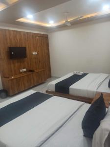 艾哈迈达巴德hotel gateway inn的一间卧室配有两张床和一台平面电视