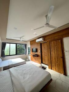艾哈迈达巴德hotel gateway inn的一间卧室配有两张床和吊扇