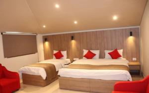 朱尼耶朱尼耶精品酒店的酒店客房 - 带两张带红色枕头的床