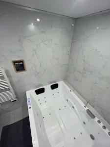 圣但尼Room & Jacuzzi - Stade de France的浴室设有白色浴缸,拥有大理石墙壁。