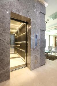 孟买Regency Hotel Malabar Hill的大厅的电梯,有石墙