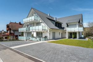 施卢赫湖Luxuswohnung Traumblick - Neubau 2023的一座带车道的大型白色房屋