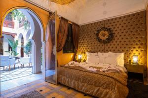 马拉喀什惊叹庭院旅馆的一间卧室设有一张床和一个开放式门廊