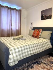 达格纳姆Forsyth Court Apartment - Two bedroom的一间卧室配有一张带 ⁇ 子毯子的床