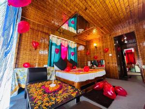 马拉里Hotel Hamta View Manali !! Top Rated & Most Awarded Property in Manali !!的一间设有一张床、一张沙发和红色气球的房间