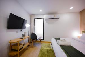 曼谷2 Bed 2 Bath / Luxury / 1 min walk to BTS Asok的酒店客房设有一张床、一张书桌和一台电视机。