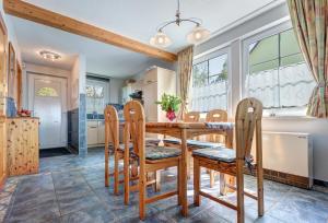 特拉森海德Ferienhaus zur frischen Brise - Whg. 1的厨房以及带木桌和椅子的用餐室。