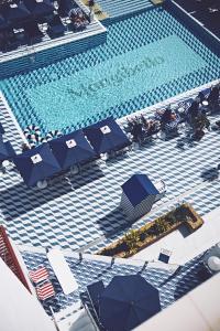 圣埃乌拉利亚Hotel Mongibello Ibiza的享有带遮阳伞和椅子的游泳池的顶部景致