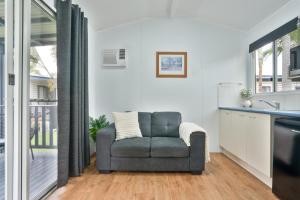 赫维湾Tasman Holiday Parks - Fraser Coast的客厅,厨房配有灰色椅子