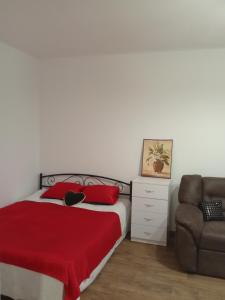 利沃夫Апартамент в Новобудові Стрийська Автовокзал的一间卧室配有一张带红色毯子和椅子的床