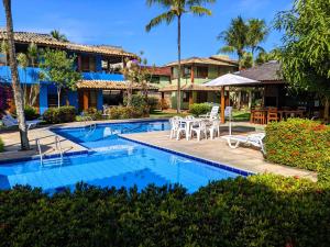 阿拉亚尔达茹达Residence Maria Vittoria Praia Arraial的一个带游泳池和桌椅的度假酒店