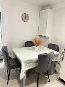 达格纳姆Stanton - Impeccable and stylish 2 bedroom的餐桌、椅子和墙上的时钟