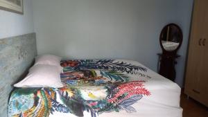 乌雷基3 bedroom apartment in Ureki的一张床上,上面有彩色的毯子和镜子