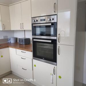 诺丁汉Nice 2 Bedroom house near City hospital的厨房配有白色橱柜和黑烤箱。