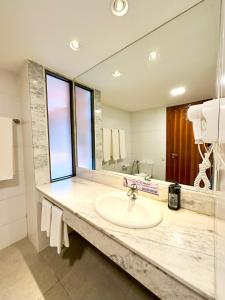 嘎林海斯港Enotel Porto de Galinhas All Inclusive的一间带水槽和大镜子的浴室