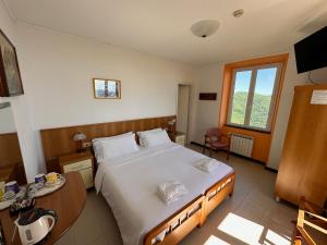 拉帕洛Hotel Montallegro的一间卧室配有一张床、一张桌子和一个窗户。