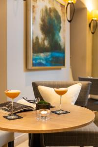 杜布罗夫尼克斯达黎格兰德精品酒店的一张木桌,上面放着两只马提尼玻璃杯