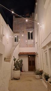 马蒂诺La Corte delle Arti的一座空洞的小巷,有一座种植了盆栽植物的建筑