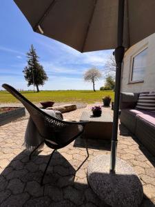 勒兹维Munkgaard Bed & Breakfast的天井配有椅子、遮阳伞和沙发。